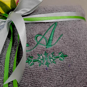 szary ręcznik z zielonym monogramem na prezent